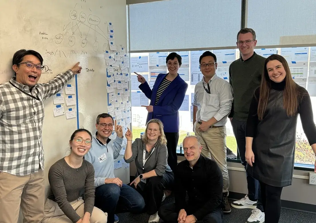 A team gathered at a wall of sticky notes during a workshop
